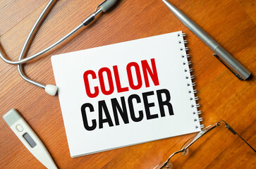 Paper with text COLON CANCER on a table with stethoscope