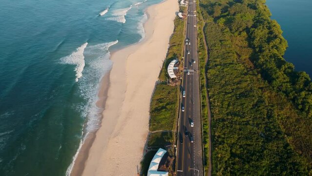 Aerial view of Reserva beach, Marapendi lagoon and car traffic on Lucio Costa avenue. Barra da Tijuca and Recreio, in Rio de Janeiro, Brazil. Sunrise. Sunny day. Drone take. Praia da Reserva.