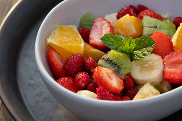 Fruit salad in a white bowl on a metal tray
