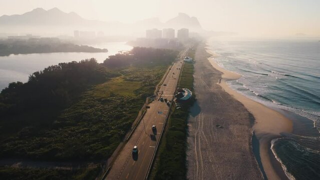 Aerial view of Reserva beach, Marapendi lagoon and car traffic on Lucio Costa avenue. Barra da Tijuca and Recreio, in Rio de Janeiro, Brazil. Sunrise. Sunny day. Drone take. Praia da Reserva.