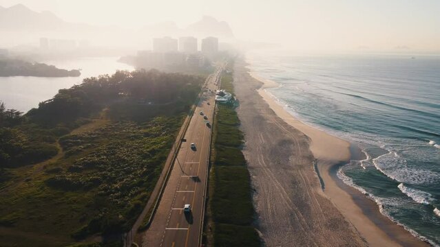 Aerial view of Reserva beach, Marapendi lagoon and car traffic on Lucio Costa avenue. Barra da Tijuca and Recreio, in Rio de Janeiro, Brazil. Sunrise. Sunny day. Drone take. Praia da Reserva.