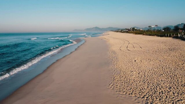 Aerial view of Reserva beach, Marapendi lagoon and car traffic on Lucio Costa avenue. Barra da Tijuca and Recreio, in Rio de Janeiro, Brazil. Sunrise. Sunny day. Drone take. Praia da Reserva.