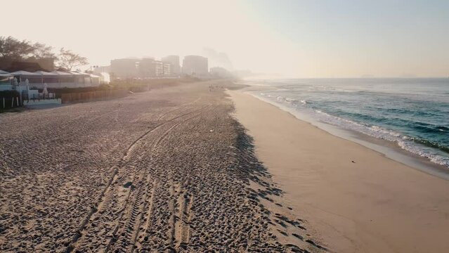 Aerial view of Reserva beach, Marapendi lagoon and car traffic on Lucio Costa avenue. Barra da Tijuca and Recreio, in Rio de Janeiro, Brazil. Sunrise. Sunny day. Drone take. Praia da Reserva.