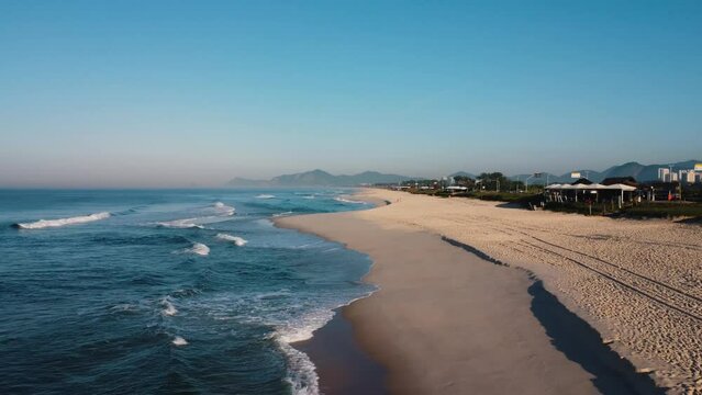 Aerial view of Reserva beach, Marapendi lagoon and car traffic on Lucio Costa avenue. Barra da Tijuca and Recreio, in Rio de Janeiro, Brazil. Sunrise. Sunny day. Drone take. Praia da Reserva.