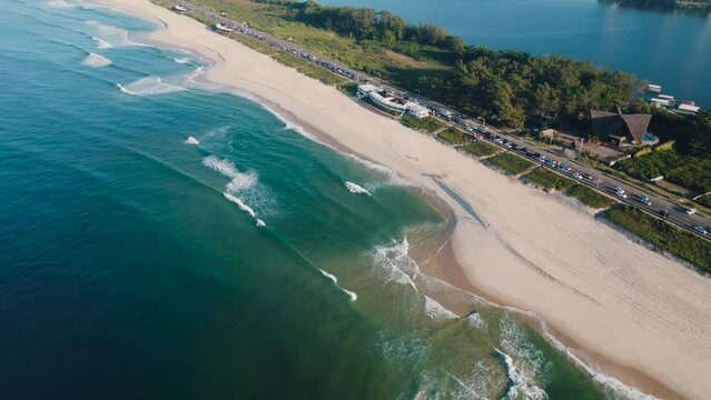 Aerial view of Reserva beach, Marapendi lagoon and car traffic on Lucio Costa avenue. Barra da Tijuca and Recreio, in Rio de Janeiro, Brazil. Sunrise. Sunny day. Drone take. Praia da Reserva.