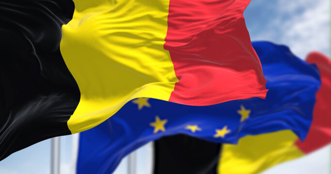 Detail of the national flag of Belgium waving in the wind with blurred european union flag in the background on a clear day