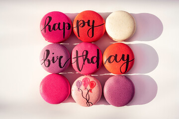 Happy Birthday red, pink and white sweet macarons desserts with text and balloons, isolated on white