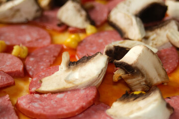 Defocus closeup ingredients for pizza on dough. Red tomato sauce, sausages, sweet corn. Homemade italian pizza. Home culinary. Blurred. Italian cuisine background. Copy space. Backdrop. Out of focus