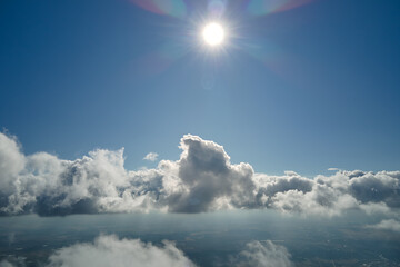 Aerial view from airplane window at high altitude of earth covered with puffy cumulus clouds...