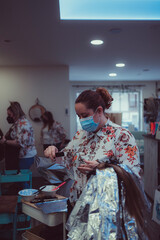 Woman dyes her hair in a barbershop, the process of dyeing her hair with foil.