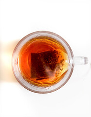 Hot tea in a glass teacup on a white table