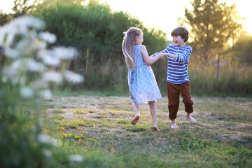 Fototapeta premium Children walk in the summer in nature. Child on a sunny spring morning in the park. Traveling with children.