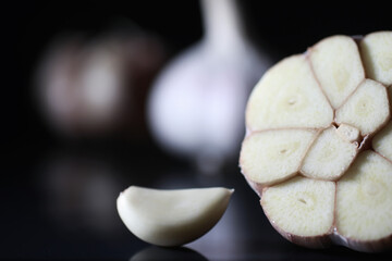 Fresh garlic clove on black background. Garlic is rich in vitamins, useful spring, good spices. Garlic sliced on a dark background. Raw sliced garlic.