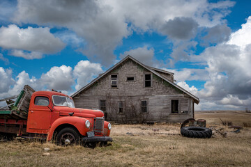 Blue sky over an old, abandoned home and truck on the prairies of Saskatchewan 