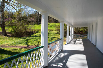 View down the long covered front porch of a colonial American home