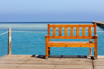 Fototapeta na wymiar wooden bench on the pontoon overlooking the turquoise sea