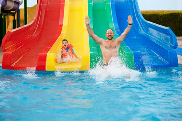 father and son on water slide in the aqua park