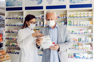 A pharmacy worker reading with patient side effects at pharmacy.