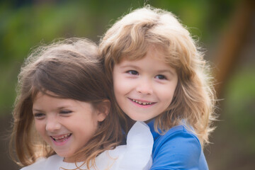 Hugging and kissing kids couple. Little lovely children outdoor. Happy children having fun outdoors. Kids playing in spring park.