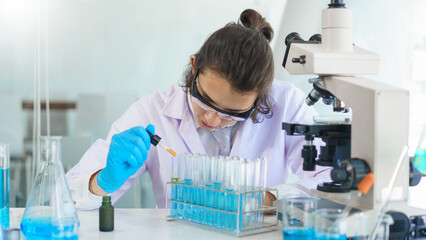 Fototapeta premium Laboratory research concept, Scientist working in lab to drop of solution into tube for research
