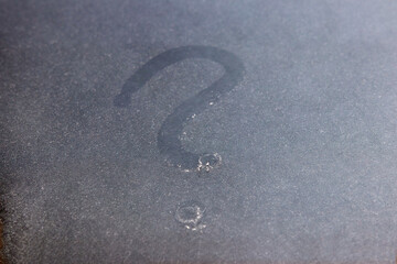 The question mark is painted on the glass with dust.