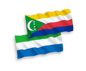 National vector fabric wave flags of Union of the Comoros and Sierra Leone isolated on white background. 1 to 2 proportion.