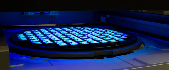 Silicon wafer with chips in UV lighting. Neon. Ultraviolet Lithography.