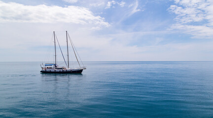 Sailboat sailing in the morning with blue cloudy sky. Luxury yacht in open waters with beautiful clouds