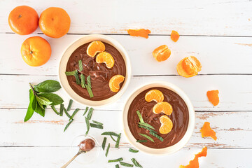 Chocolate cream in bowls with oranges and mint leaves