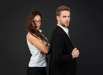 successful businessman and brunette businesswoman on black background, partners