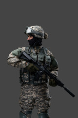 Shot of military man dressed in modern camouflage clothes holding rifle.