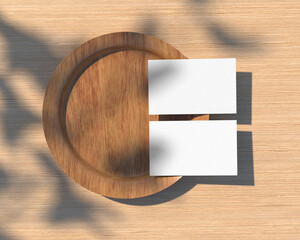Two white standard size bank empty paper business cards on a wooden plate place on wood table