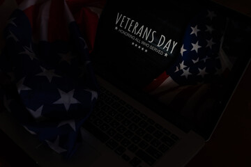 laptop with usa flag and inscription veterans day.