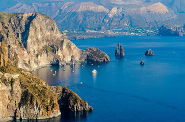 Stunning view of Valle Muria beach in Lipari and the Faraglioni. In the background the crater of Vulcano Island. Aeolian islands, Sicily  © Roberto