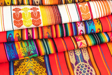 Colorful Andean fabric textiles on the local souvenir market in Otavalo, Ecuador. South America. - obrazy, fototapety, plakaty