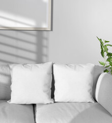 Two plain white square pillows on a white sofa