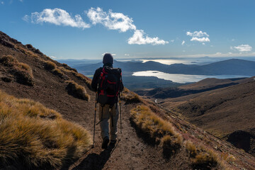 Hiking northern slope of Tongariro Alpine Crossing, Lake Rotoaira and Lake Taupo in the distance.