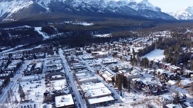 Aerial panorama view of Town of Canmore and Canadian Rockies in winter. Alberta, Canada. Snow capped Mount Rundle mountain range.