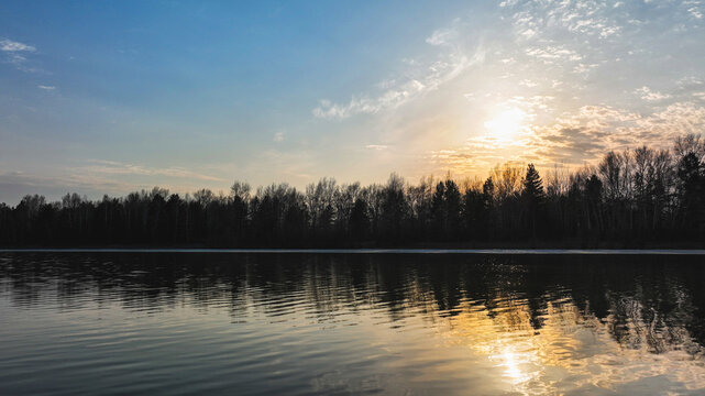 Sunset on the river against the background of the forest © GMisman