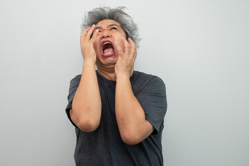 Portrait of a furious senior grey-haired man yelling and screaming and gesturing in fear with hands and face on isolated background