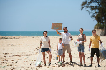 Group of activists picking up garbage on beach and asking society to keep beach clean