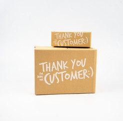Two closed cardboard boxes taped up, and there is a Thank you for being our customer beside the parcel box for delivery and shopping online concept design isolated on white background.