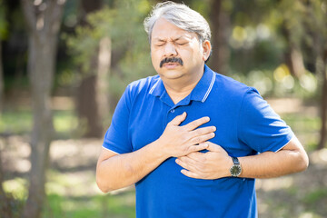 Senior indian man having chest pain outdoor, heat attach, cardiac arrest, Health care and fitness, Mature adult cardiology. problem.