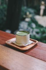 Hot Organic Matcha Green Tea in japanese cup on wooden table