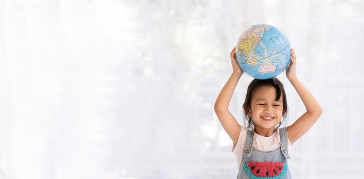 Banner of happy aasian little girl is raising the globe model with love and concept of preserve, save and protect the earth from environment problem and global warming, kid education at home.