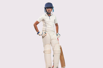 full length of a boy in cricket uniform  standing with bat 