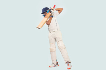 A boy in cricket uniform playing Cricket