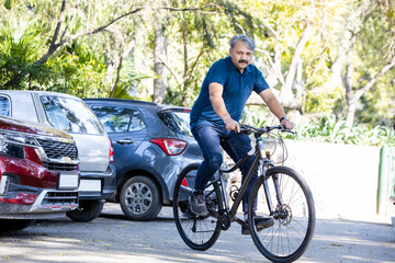 Obraz premium Happy Indian asian retired senior man walking with bicycle in the park outdoor.