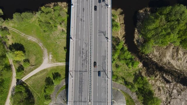 Cars crossing the bridge above the river on a highway aerial view drone footage