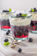 Homemade blue jelly served in glass with blueberries.